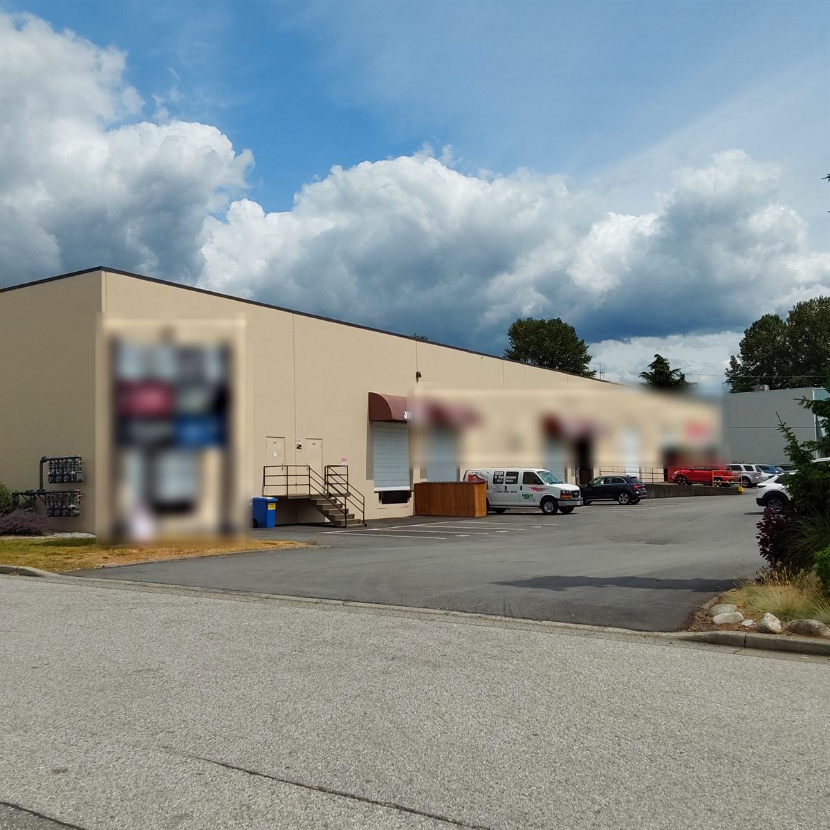 Single-storey commercial and light-industrial building under blue sky, North Vancouver