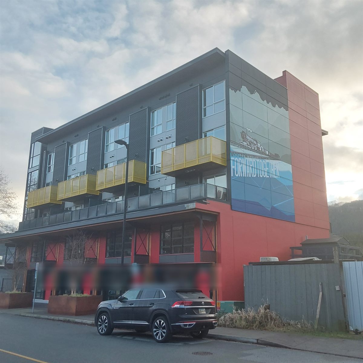 Modern mixed-use low-rise building set against the mountains, Squamish
